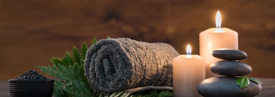 Image of a spa with towels, candles and stacked stones.